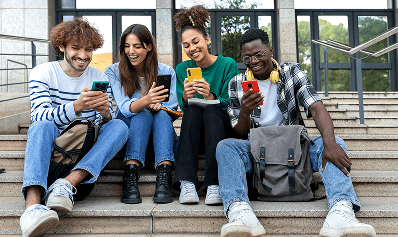 a group of people sitting on steps looking at their phones