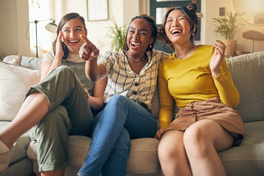 a group of women sitting on a couch laughing